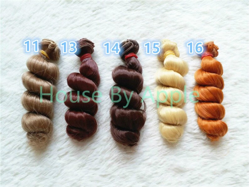 Peut inclure: Six extensions de cheveux boucl&eacute;s de diff&eacute;rentes couleurs, &eacute;tiquet&eacute;es 11, 13, 14, 15 et 16. Les couleurs sont blond, brun, brun fonc&eacute;, blond clair et orange.