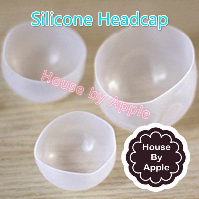 May include: Three clear silicone headcaps of varying sizes. The headcaps are made of a flexible, translucent material. The text "House by Apple" is visible in the image.
