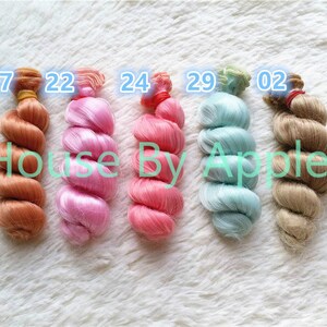 Peut inclure: Cinq couleurs diff&eacute;rentes de cheveux de poup&eacute;e, dans un style boucl&eacute;, avec les num&eacute;ros 17, 22, 24, 29 et 02 &eacute;tiquet&eacute;s sur chacun.