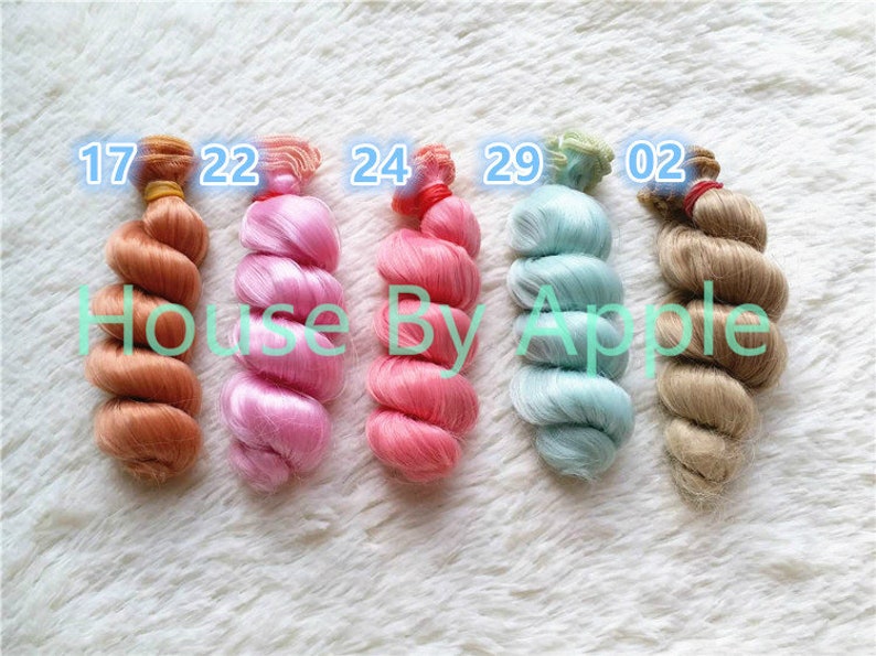 Peut inclure: Cinq couleurs diff&eacute;rentes de cheveux de poup&eacute;e, dans un style boucl&eacute;, avec les num&eacute;ros 17, 22, 24, 29 et 02 &eacute;tiquet&eacute;s sur chacun.