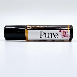 Puede incluir: Un pequeño frasco de vidrio transparente con tapón negro. El frasco contiene un líquido dorado y tiene una etiqueta blanca con la palabra "Pure" en texto negro y un diseño floral rosa. Las palabras "Hormone Balancing" están debajo.