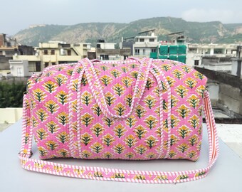 May include: Pink and white striped cotton duffel bag with a floral print. The bag has two top handles and a long shoulder strap.