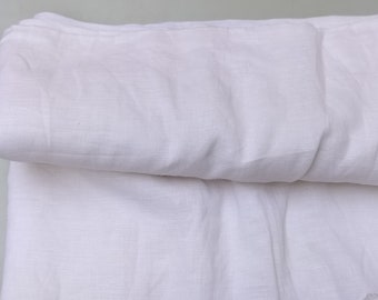 May include: A white linen fabric folded in half. The fabric has a soft, textured surface.