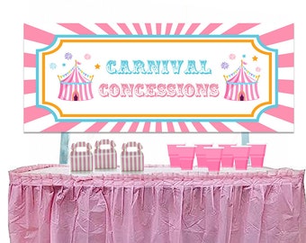 Op de afbeelding: Roze-wit gestreept spandoek met de tekst "Carnival Concessions" en twee roze-blauw gestreepte circus tenten. Het spandoek hangt boven een roze tafel met roze-wit gestreepte dozen en roze bekers.