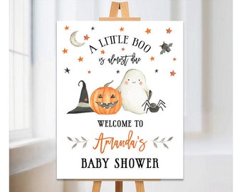 May include: A white sign with the text "A Little Boo is almost due" and a pumpkin, ghost, and spider illustration. The sign also says "Welcome to Amanda's Baby Shower".