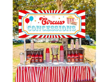Puede incluir: Una pancarta roja y blanca a rayas con el texto "Circus Concessions" y una imagen de dibujos animados de palomitas de maíz y globos. La pancarta está colgada sobre un puesto de madera con tela a rayas rojas y blancas y varias tazas rojas y blancas.