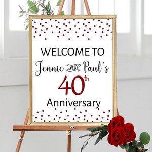 May include: Welcome to Jennie and Paul's 40th Anniversary sign with a red polka dot background. The sign is on a wooden easel.