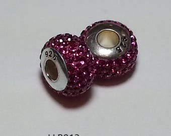 May include: Two silver charm beads with pink crystal accents. The beads are round and have a hole in the center for threading onto a bracelet or necklace. The beads are marked with "925" on the side.