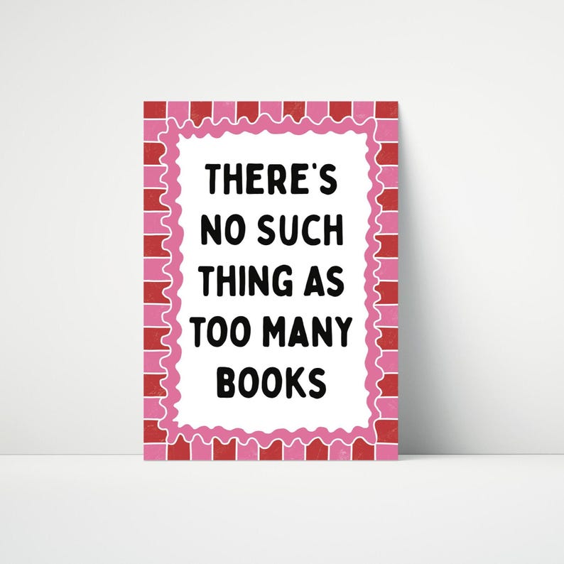 May include: A rectangular print with the text "THERE'S NO SUCH THING AS TOO MANY BOOKS" in black. The text is centered on a white background, framed by a pink scalloped border and a red brick-like pattern.