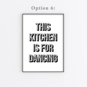 May include: A black and white framed print with the text "This kitchen is for dancing" in a bold, 3D-style font.