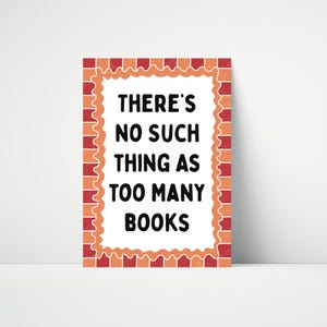 May include: A rectangular sign with a white background and the text "THERE'S NO SUCH THING AS TOO MANY BOOKS" in black. The sign has a decorative orange and red border. The sign is designed to be displayed.