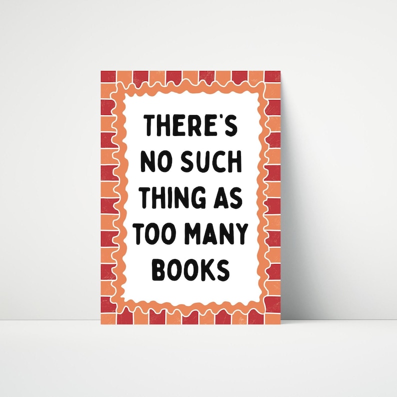 May include: A rectangular sign with a white background and the text "THERE'S NO SUCH THING AS TOO MANY BOOKS" in black. The sign has a decorative orange and red border. The sign is designed to be displayed.
