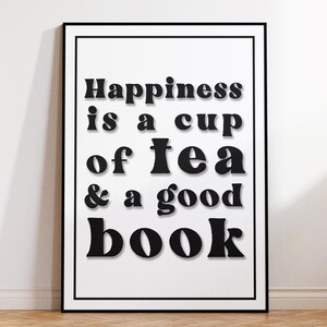 May include: Black and white typography print with the text "Happiness is a cup of tea & a good book".