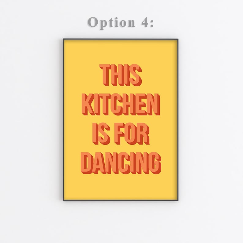 May include: A yellow poster with black frame featuring the text "This Kitchen is for Dancing" in orange letters with a 3D effect.