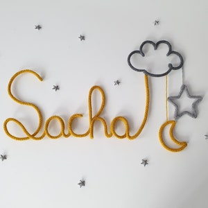 Knitted first name with cloud decoration and moon and star tassels