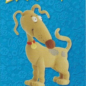 May include: A tan knitted plush toy dog called Spike from the Rugrats cartoon. The toy has a red collar with a gold tag and a grey spot on its back. The background is blue with white stars and other shapes.