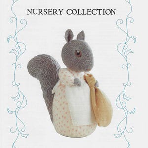May include: A grey knitted squirrel doll wearing a pink and white dress and carrying a yellow sack. The doll is part of the Beatrix Potter Nursery Collection and is called "Goody Tiptoes".