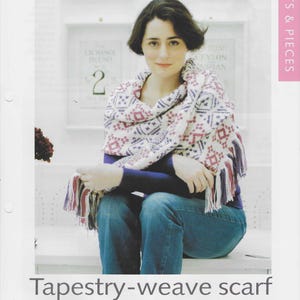 May include: A woman wearing a tapestry-weave scarf with a geometric pattern in red, white, and blue. The scarf has fringe and is draped over a blue shirt and jeans. The text "Tapestry-weave scarf" is at the bottom of the image.