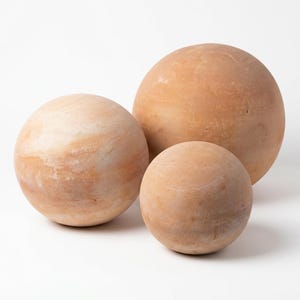 May include: Three spherical decorative objects in varying sizes. The spheres have a light brown, earthy tone with subtle variations in color. The largest sphere is approximately 12 inches in diameter, the medium sphere is 9 inches, and the smallest is 6 inches.
