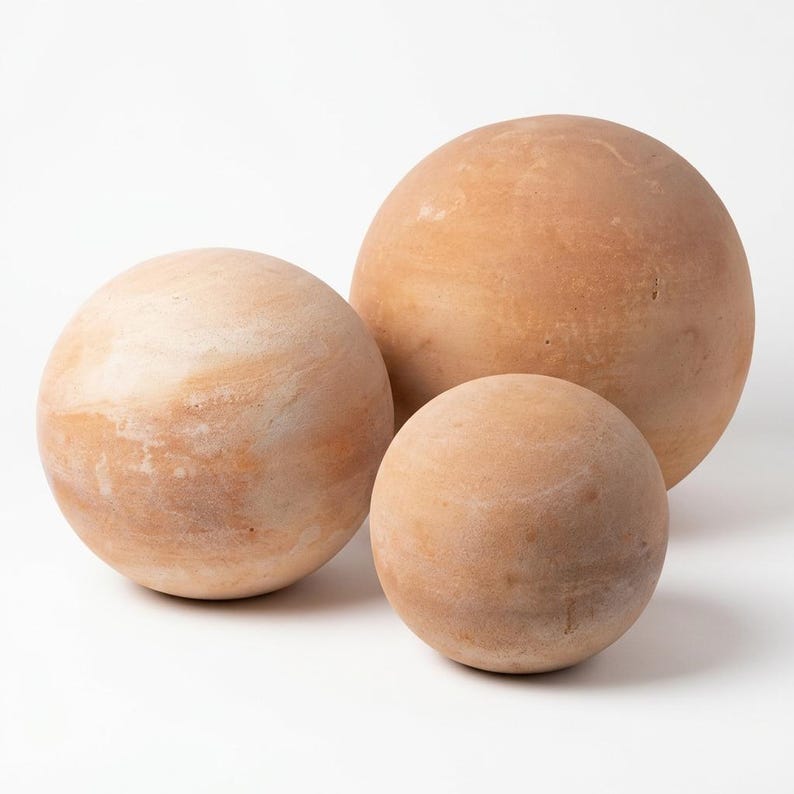 May include: Three spherical decorative objects in varying sizes. The spheres have a light brown, earthy tone with subtle variations in color. The largest sphere is approximately 12 inches in diameter, the medium sphere is 9 inches, and the smallest is 6 inches.