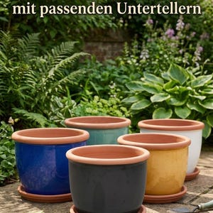 Op de afbeelding: Een set van vijf keramische plantenpotten in blauw, donkergrijs, geel, turquoise en wit, elk met een rand van natuurlijk terracotta en een bijpassende schotel. De tekst Exklusive Keramik-Sets mit passenden Untertellern is bovenaan zichtbaar.
