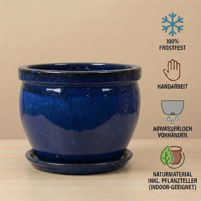May include: A glossy, deep blue ceramic planter with a matching saucer. The round pot has a wide opening and a slightly curved body. The image includes text indicating it is frost-resistant, handmade, and suitable for indoor use.