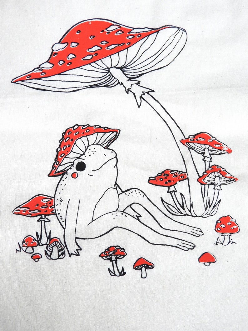 May include: A black and white line drawing of a frog sitting under a red and white mushroom. The frog is surrounded by smaller red and white mushrooms.