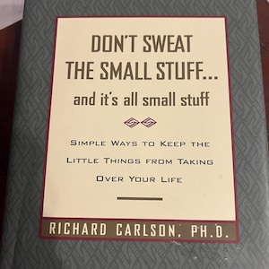 Może przedstawiać: Książka w twardej oprawie zatytułowana "DON'T SWEAT THE SMALL STUFF... and it's all small stuff." Okładka książki zawiera kremowy prostokąt z tytułem pogrubioną, ciemnoczerwoną czcionką. Poniżej tytułu widnieje napis "SIMPLE WAYS TO KEEP THE LITTLE THINGS FROM TAKING OVER YOUR LIFE."