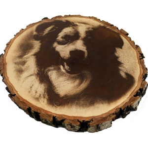 May include: A wood slice with a black and white photo of a dog's face burned into the surface.