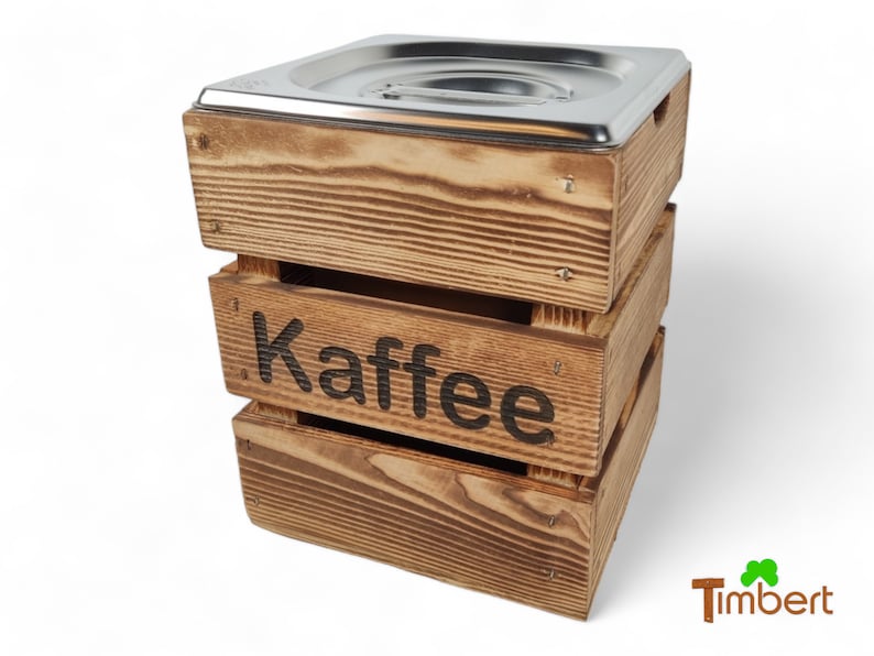 May include: A wooden box with a stainless steel lid, labeled "Kaffee" in black lettering. The box is made of rustic wood with a natural finish.