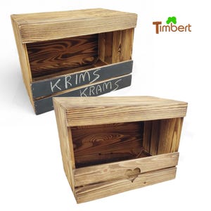 Könnte beinhalten: Zwei Holzkisten mit einem Regal und einer Schiefertafel-Front. Die obere Kiste hat die Worte "KRIMS KRAMS" auf der Schiefertafel geschrieben. Die untere Kiste hat einen herzförmigen Ausschnitt auf der Vorderseite.