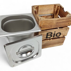 May include: A stainless steel food container with a lid and a wooden crate labelled "Bio".