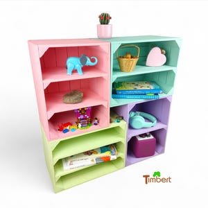 May include: A set of six colorful wooden storage crates stacked to create a shelf unit. The crates are painted in pastel shades of pink, green, and purple. The shelves are decorated with toys, books, and other items.
