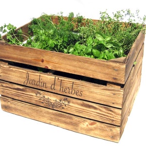 May include: A wooden crate with the words "Jardin d'herbes" inscribed on the side. The crate is filled with various herbs, including parsley, dill, and thyme.