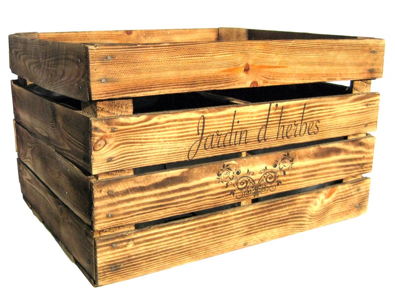 May include: A rustic wooden crate with a distressed brown finish. The crate has a label that reads "Jardin d'herbes" with a decorative floral design.