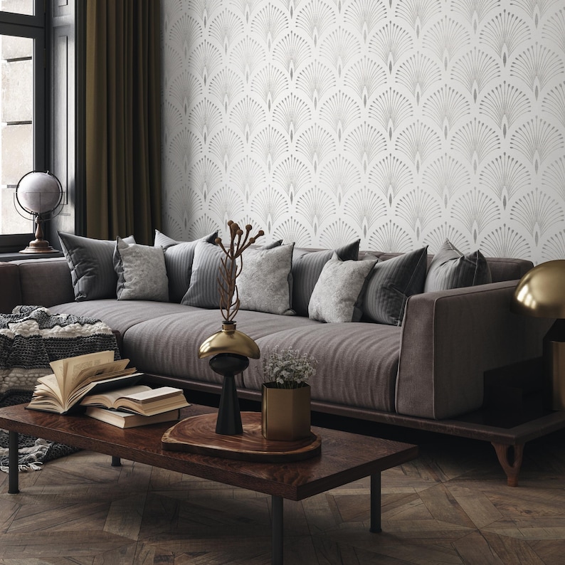 May include: A grey sofa with cushions sits in a living room with a grey and white patterned wallpaper. A wooden coffee table with a vase and a plant sits in front of the sofa.