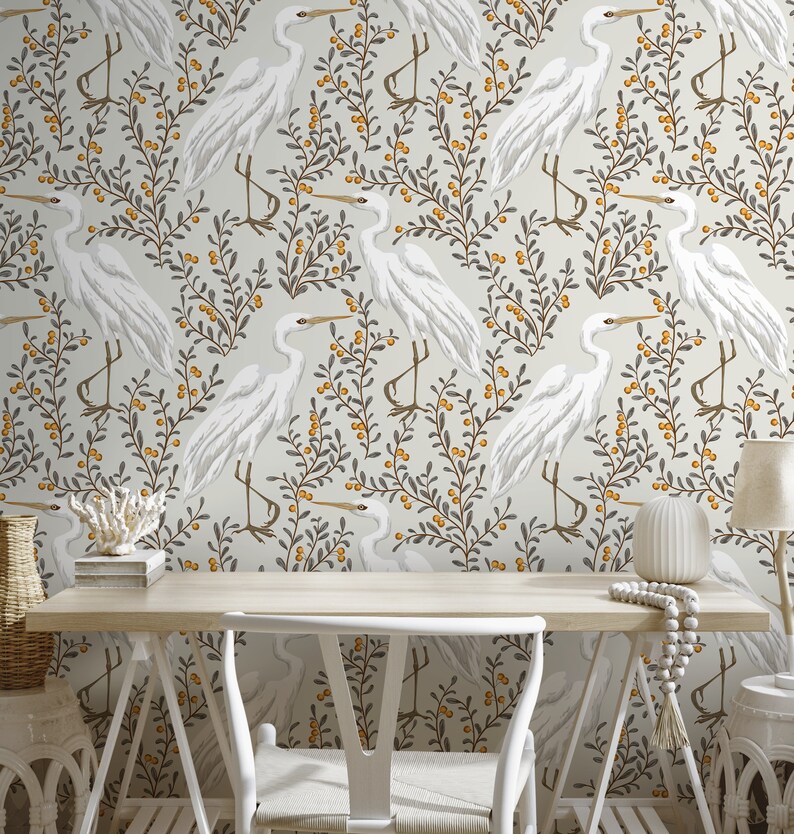 May include: White wallpaper with a repeating pattern of white birds, grey branches, and yellow berries. The wallpaper is in a room with a white desk, a white chair, and a white vase.