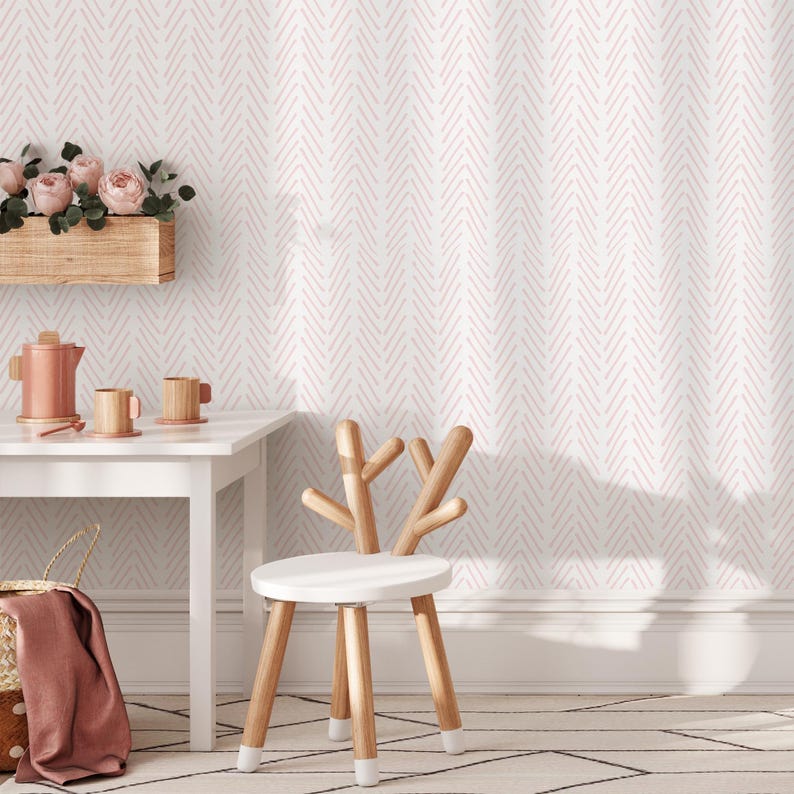 K&ouml;nnte beinhalten: Ein wei&szlig;er Holzstuhl mit einem Hirschgeweih-Design, ein wei&szlig;er Tisch mit einer pink-wei&szlig;en Chevron-Tapete im Hintergrund.
