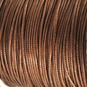 Könnte beinhalten: Nahaufnahme einer Spule mit braunem Kordel. Die Kordel scheint eng gewickelt zu sein, mit einer geflochtenen Textur. Die Farbe ist ein warmes, mittleres Braun, was auf einen natürlichen oder erdigen Ton hindeutet. Die Kordel wird wahrscheinlich zum Basteln oder zur Schmuckherstellung verwendet.