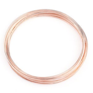 May include: A coil of rose gold coloured wire. The wire is thin and delicate, and it is perfect for jewellery making or other craft projects.