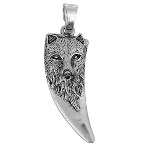 Peut inclure: Pendentif argenté en forme de dent de loup. Le haut du pendentif représente une tête de loup détaillée, avec des détails de fourrure et des traits du visage. Il possède une boucle pour une chaîne.