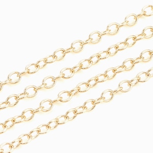 Op de afbeelding: Vier strengen gouden ketting, elk met een andere lengte, liggen op een witte achtergrond. De kettingen zijn gemaakt van ovale schakels.