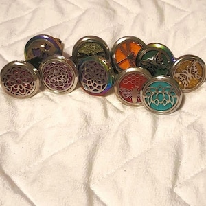 May include: Assortment of 10 round metal car air fresheners with different designs. The designs include a butterfly, a dragonfly, a honeycomb, a flower, and a glitter design. The air fresheners are silver with a rainbow iridescent finish.