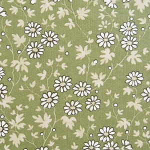 Könnte beinhalten: Ein grüner Stoff mit einem sich wiederholenden Muster aus weißen Blüten mit schwarzen Umrissen. Die Blüten sind in einem zufälligen Muster auf dem Stoff angeordnet.