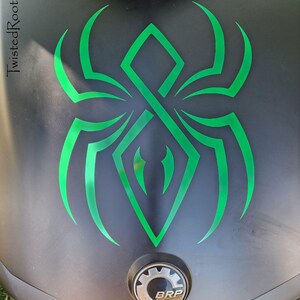 a close-up view of a motorcycle's front end, showcasing a distinctive green and black design on the hood.