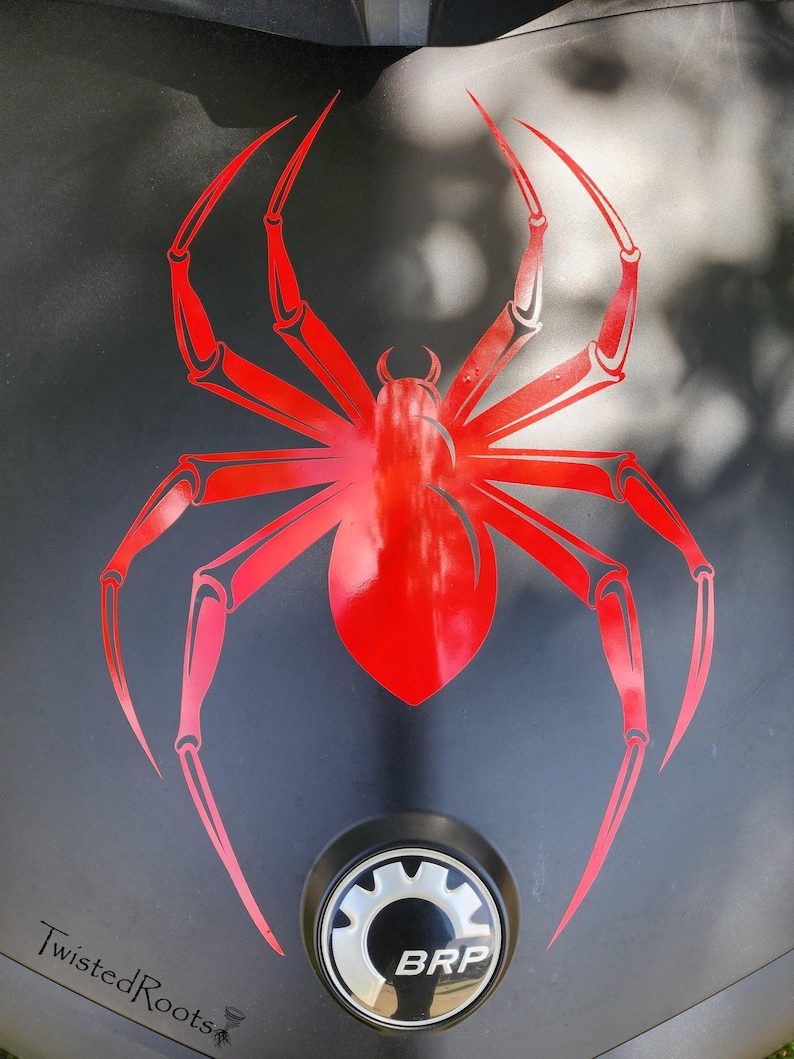 a close-up view of a black surface with a red spider design prominently displayed.