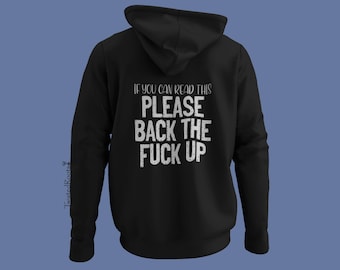 Puede incluir: Una sudadera negra con capucha que presenta texto blanco desgastado en la parte posterior que dice, IF YOU CAN READ THIS PLEASE BACK THE FUCK UP. La prenda incluye capucha, mangas largas y el pequeño texto vertical TwistedRoots en el lado izquierdo.