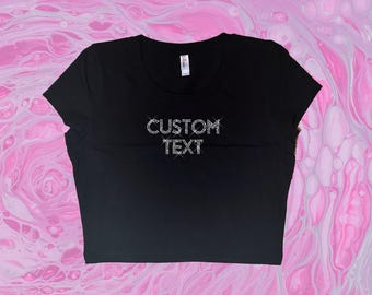 May include: Black cropped t-shirt with the text "CUSTOM TEXT" in rhinestones.