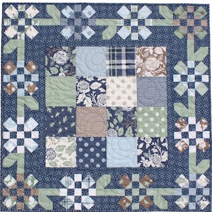 Könnte beinhalten: Eine blaue und grüne Patchwork-Decke mit einem Blumenmuster. Die Decke besteht aus Quadraten aus verschiedenen Stoffen, die jeweils ein einzigartiges Design haben. Die Decke ist mit einem blauen Rand eingefasst.