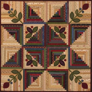 May include: A quilt with a log cabin pattern in shades of brown, green, red, and blue. The quilt is decorated with appliqued floral designs in shades of green and brown.